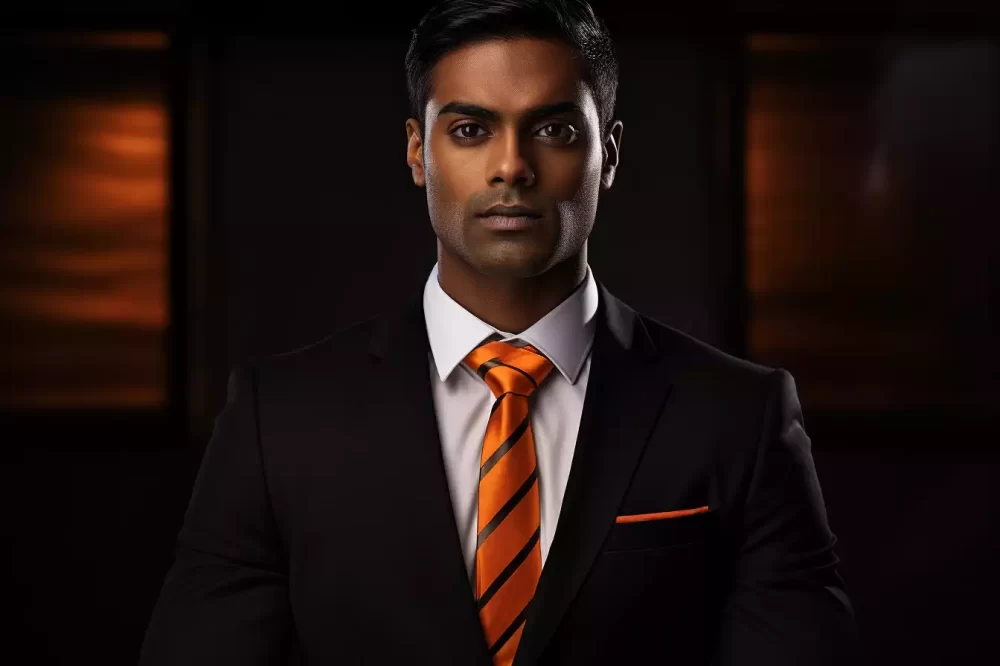 Indian man on black suit orange silk tie